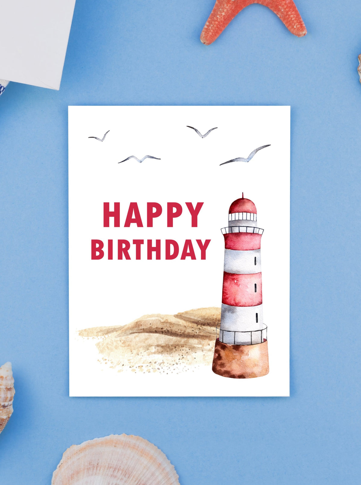 "A picturesque sandy beach with a red and white lighthouse set against a serene coastal backdrop, complemented by a heartfelt Happy Birthday in Red Lettering card design, evoking gratitude and a sense of calm seaside "