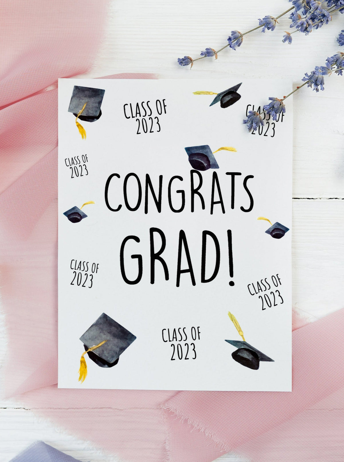 class of 2023 congrats grad graduation card. Graduation hats and class of 2023 arranged all over the face of the card. Black caps and gold tassels.
